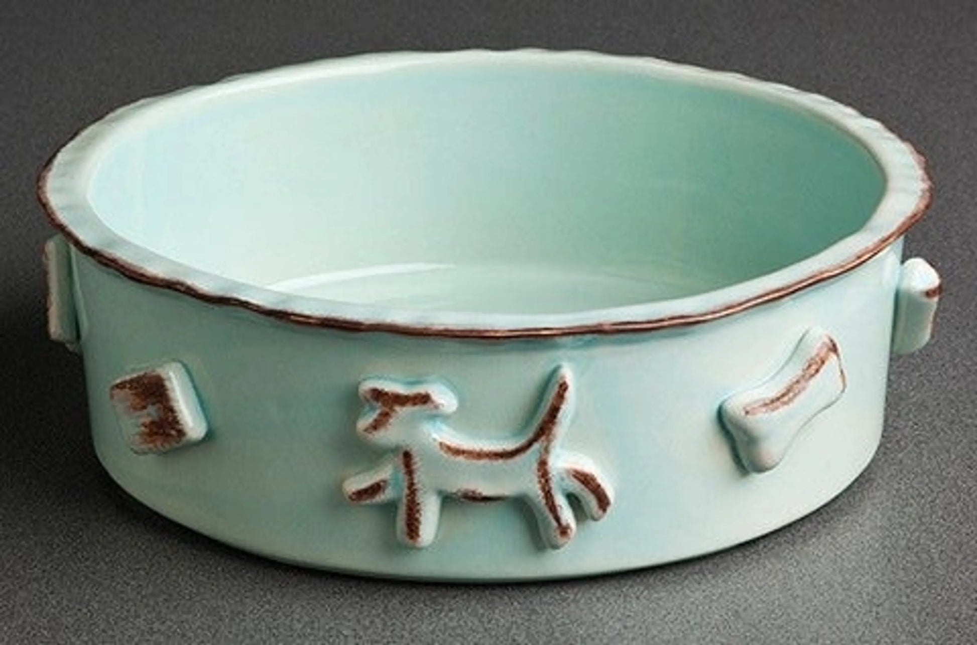 Ceramic bowl with dog and bone designs on a gray background