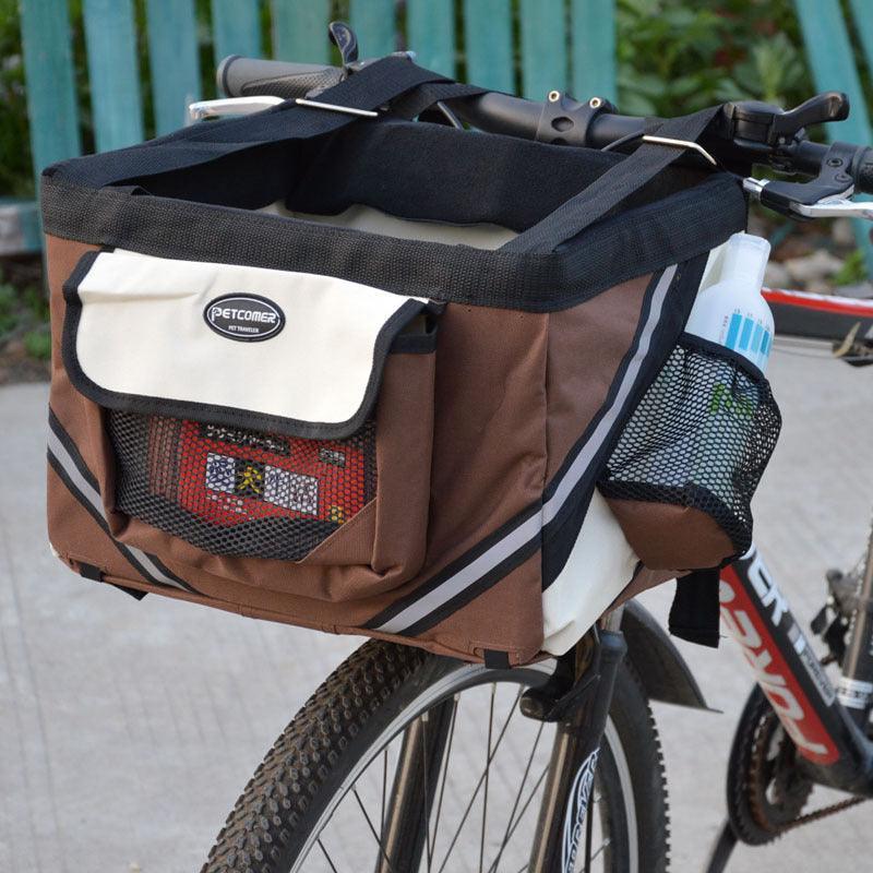 Brown bicycle basket with pet carrier attached to a bike, on a blurred background.