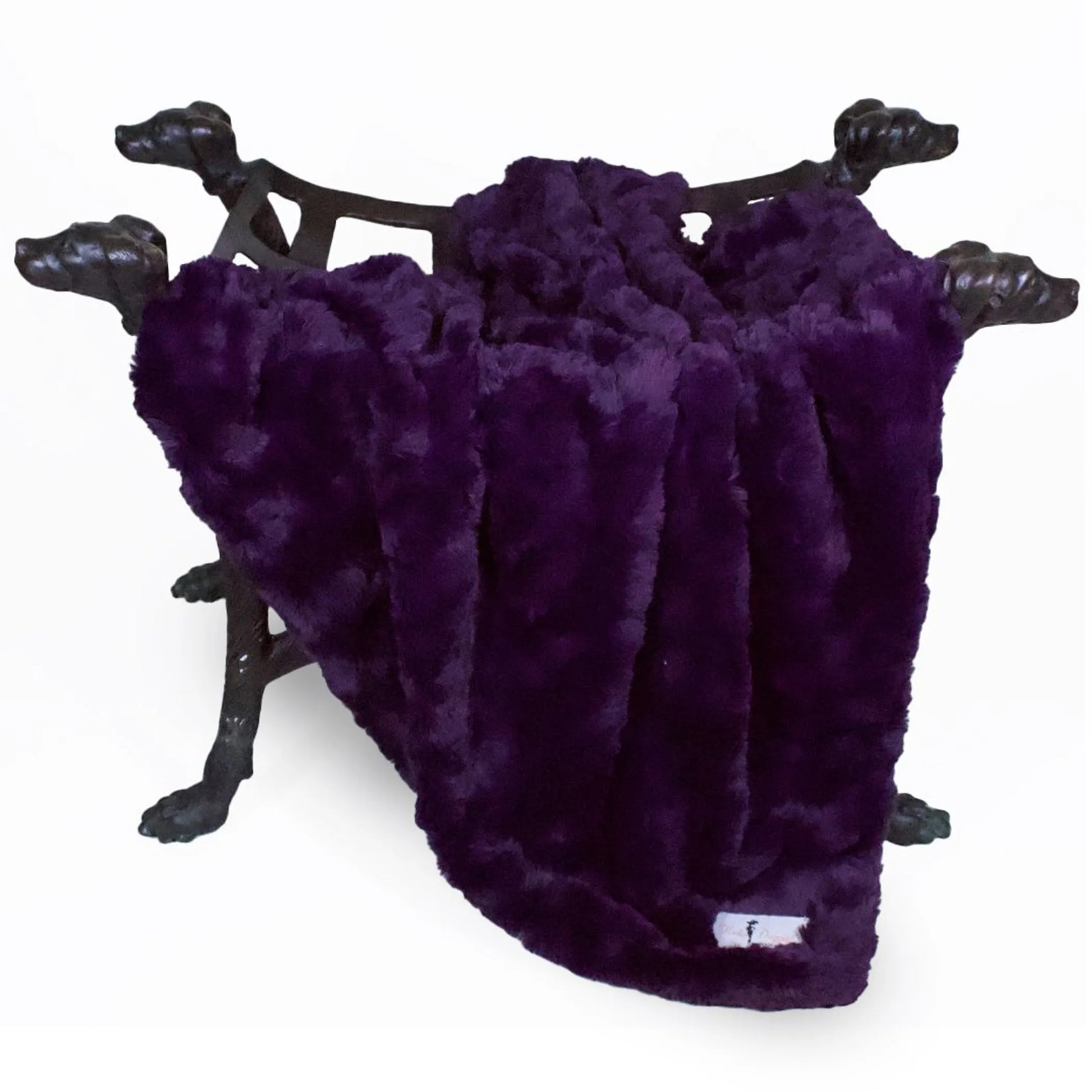 Purple blanket draped over a black metal chair on a white background