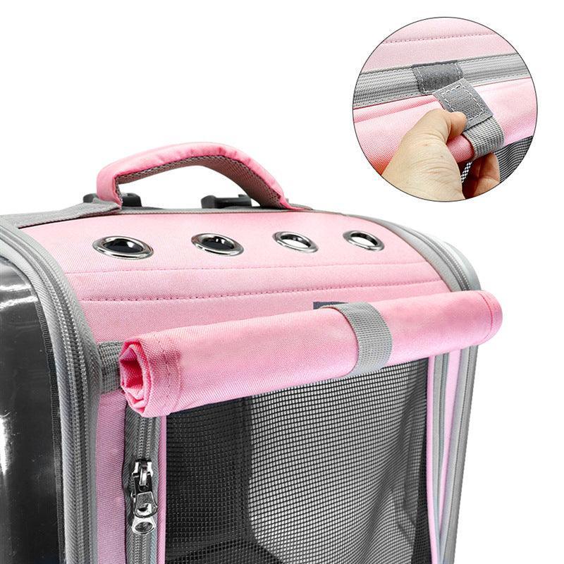Pink pet carrier with handle and mesh side, close-up of handle grip.